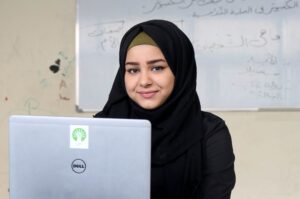 A young girl sitting behind a computer