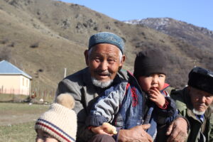 an old man is olding a child in his arms